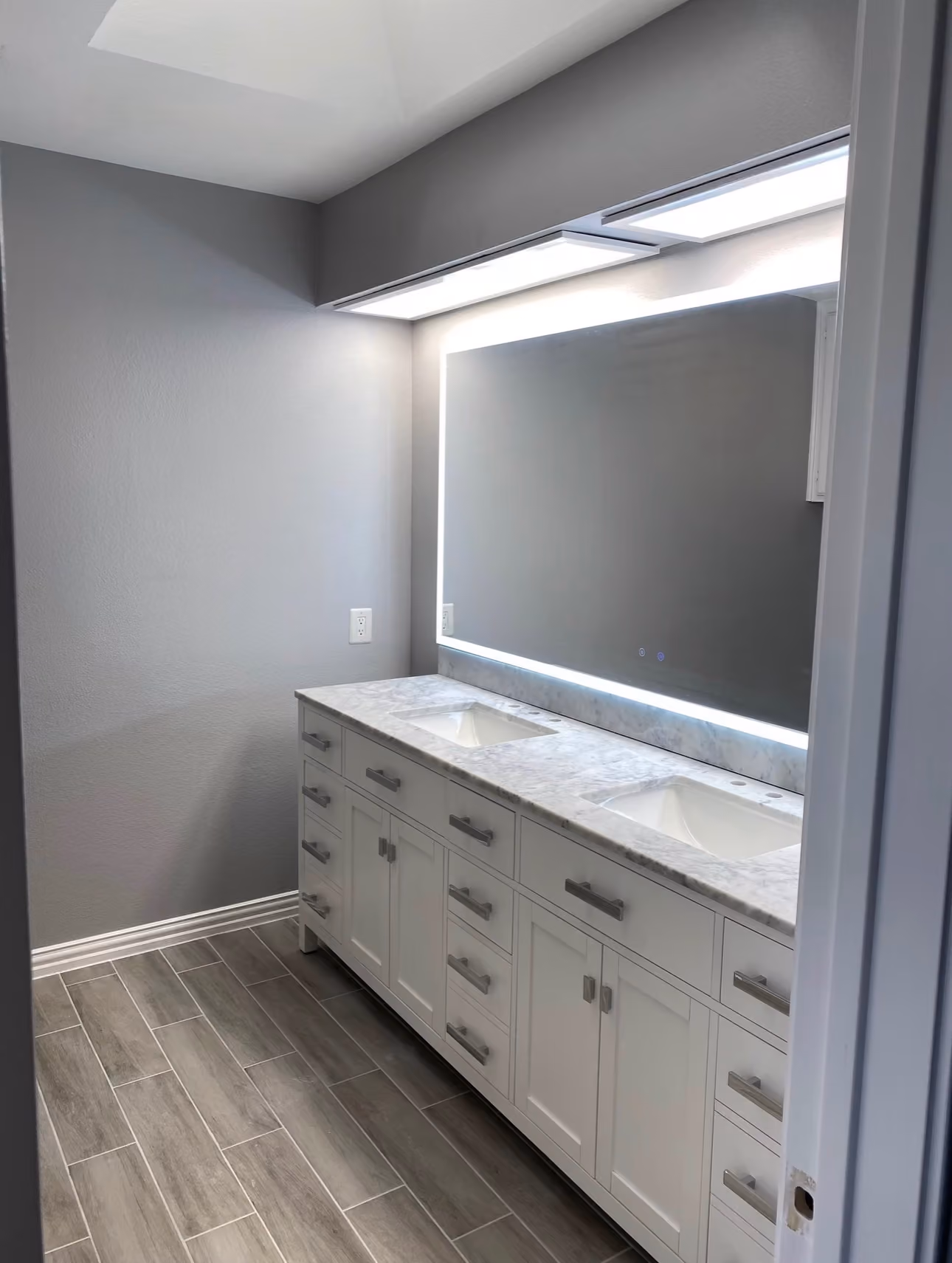 Complete bathroom update with fresh paint, new tile flooring, a custom vanity, and modern lighting