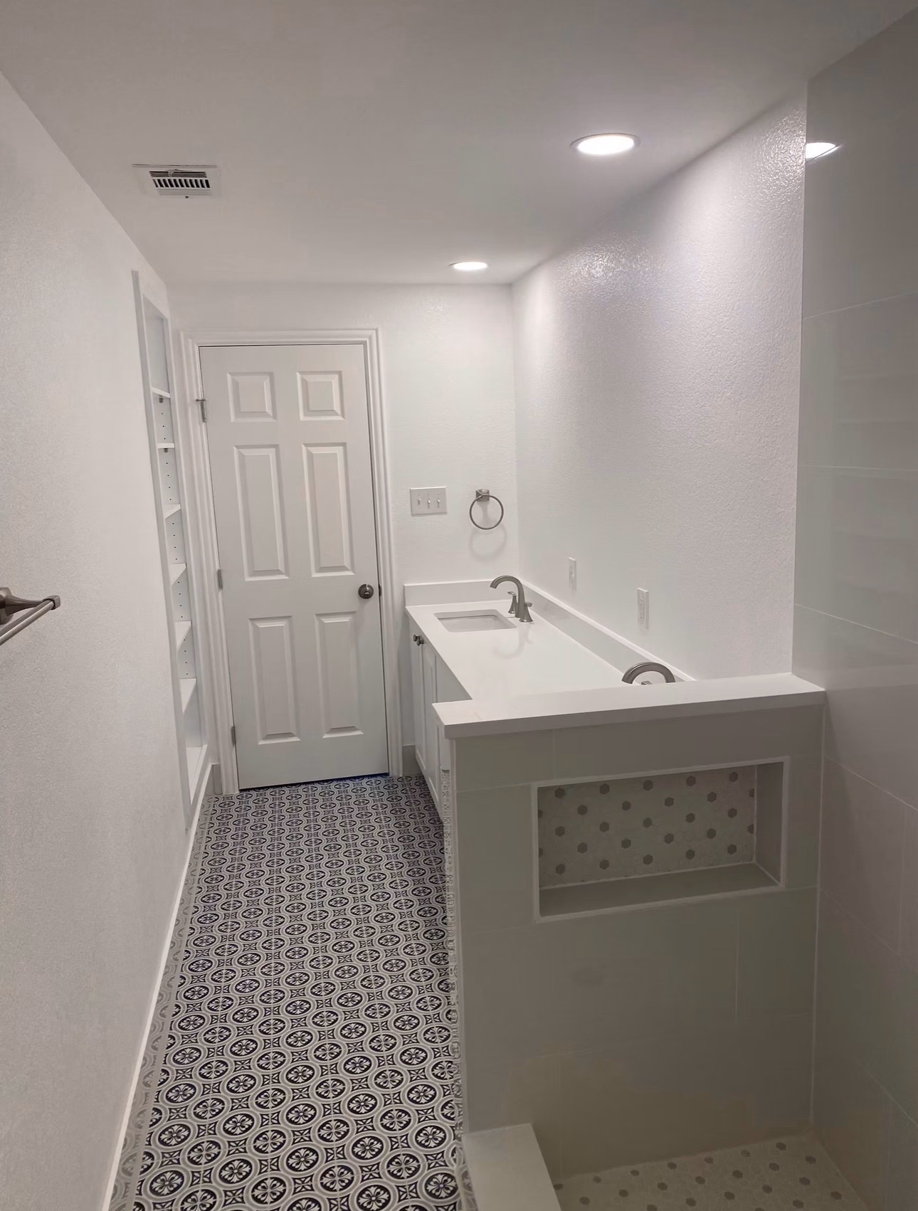 Bathroom renovation with fresh paint, new floor tile, and a new vanity